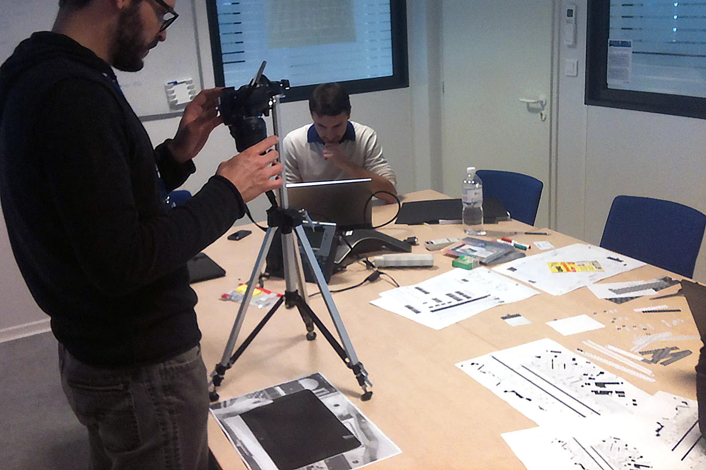 The team photographing paper interface pieces on a table, capturing low-fidelity prototypes for testing