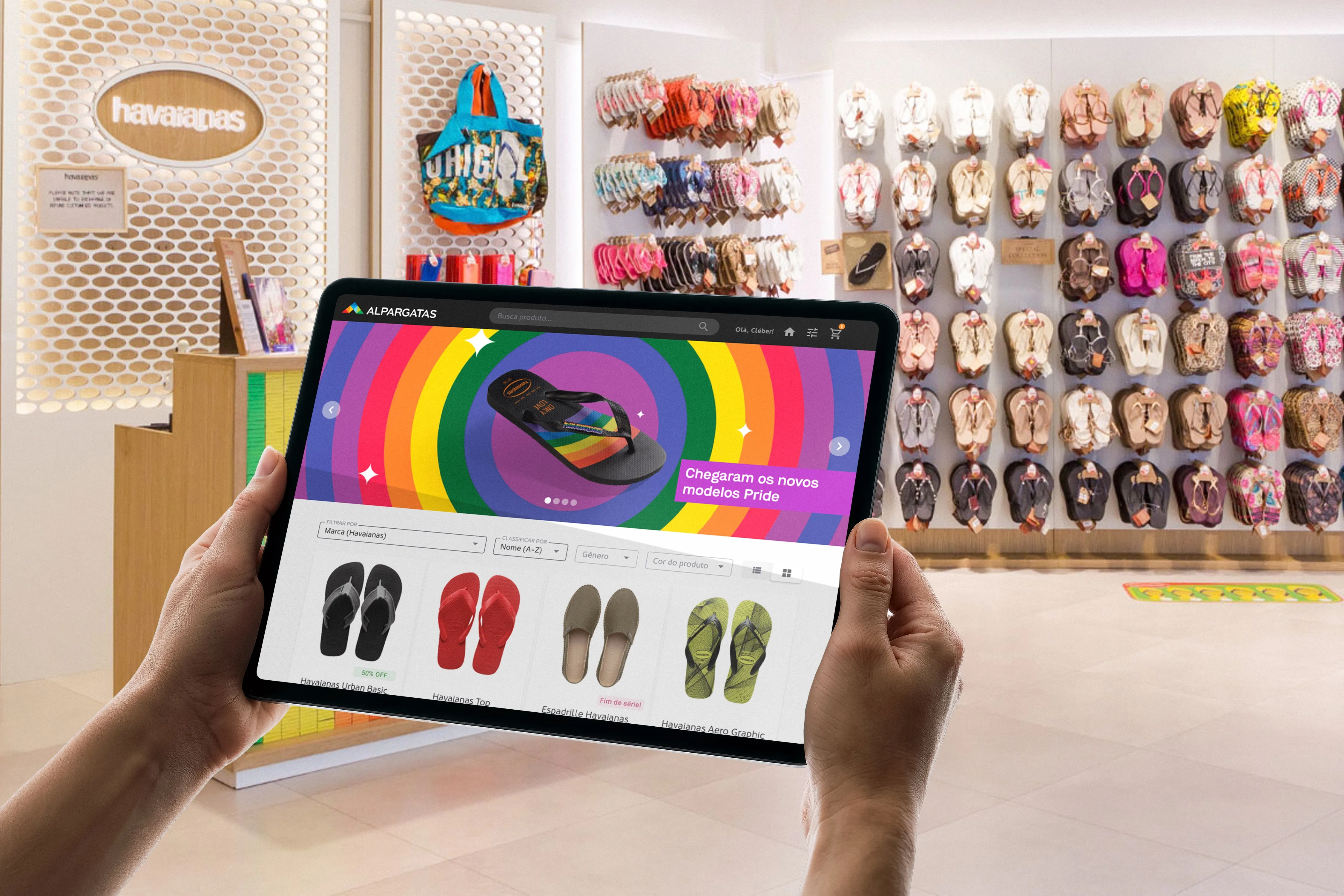 Hands holding a tablet running the new B2B ordering platform inside a Havaianas store, flip-flops behind